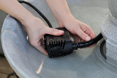 500 GPH Fountain Pump with hands attaching 1/2 inch Vinyl Tubing.