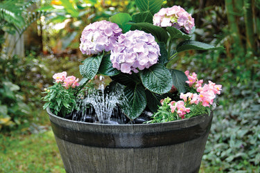 Container Fountain Project, planter fountain. Flowers in a planter with a fountain water spray.
